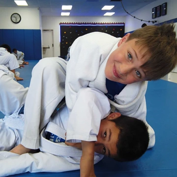 Kids practicing ground techniques during jiu-jitsu class